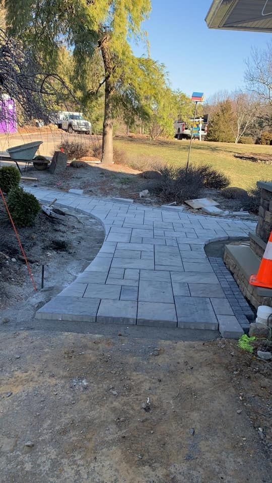 A brick walkway is being built in front of a house