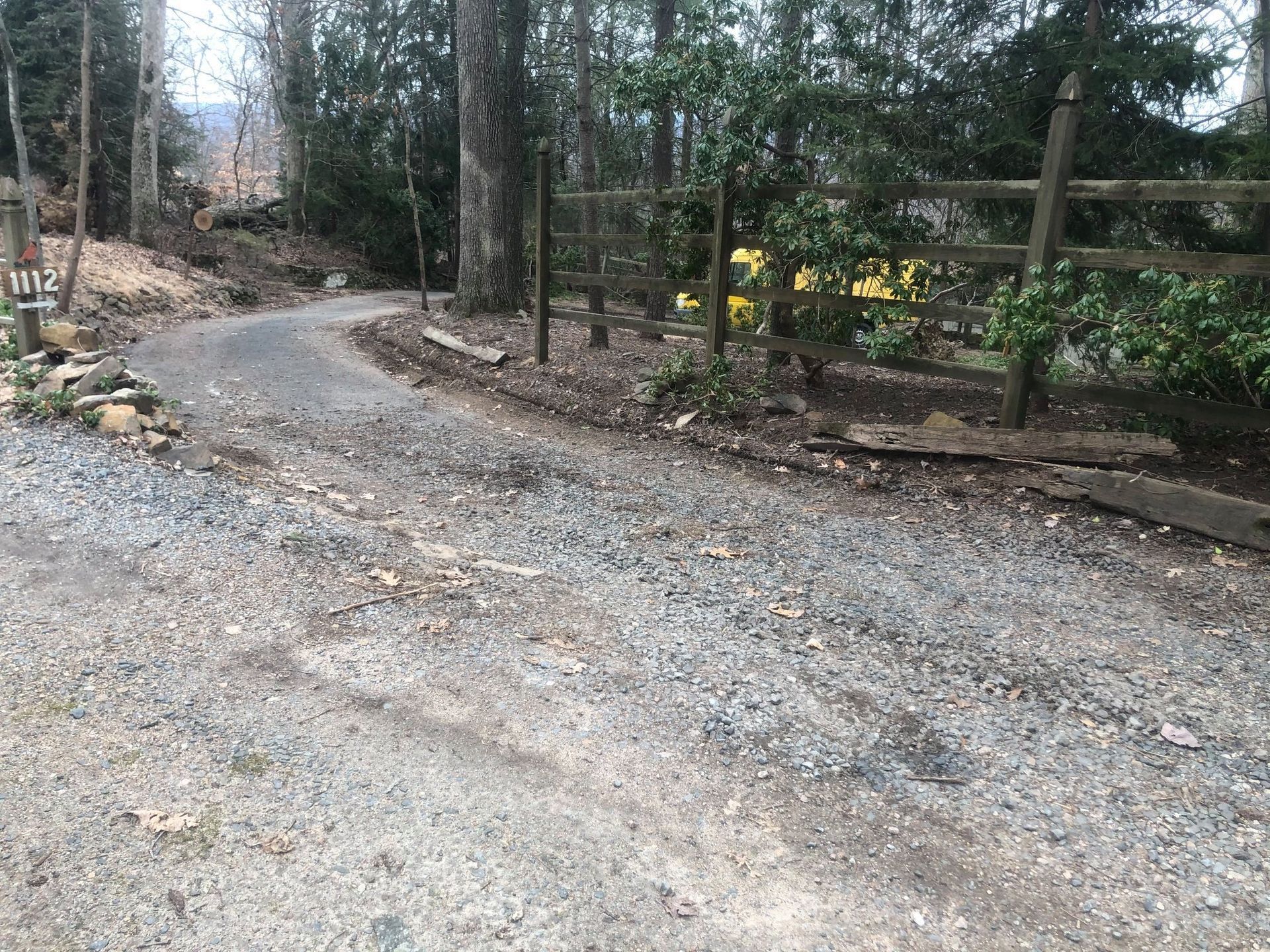 A gravel road with a wooden fence on the side of it