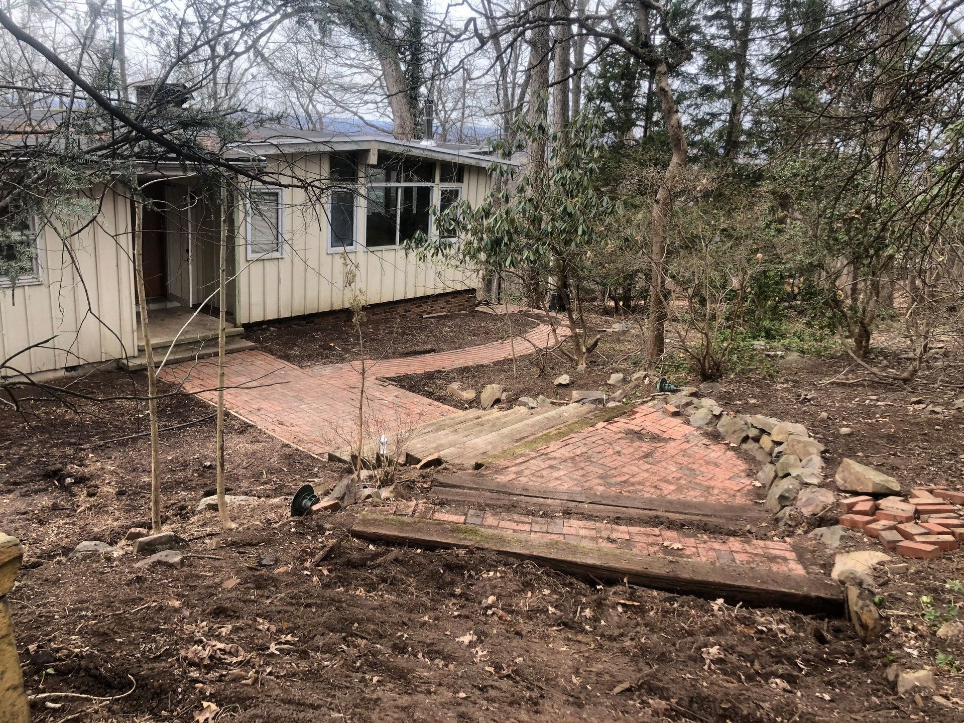 A house in the middle of a forest with a path leading to it
