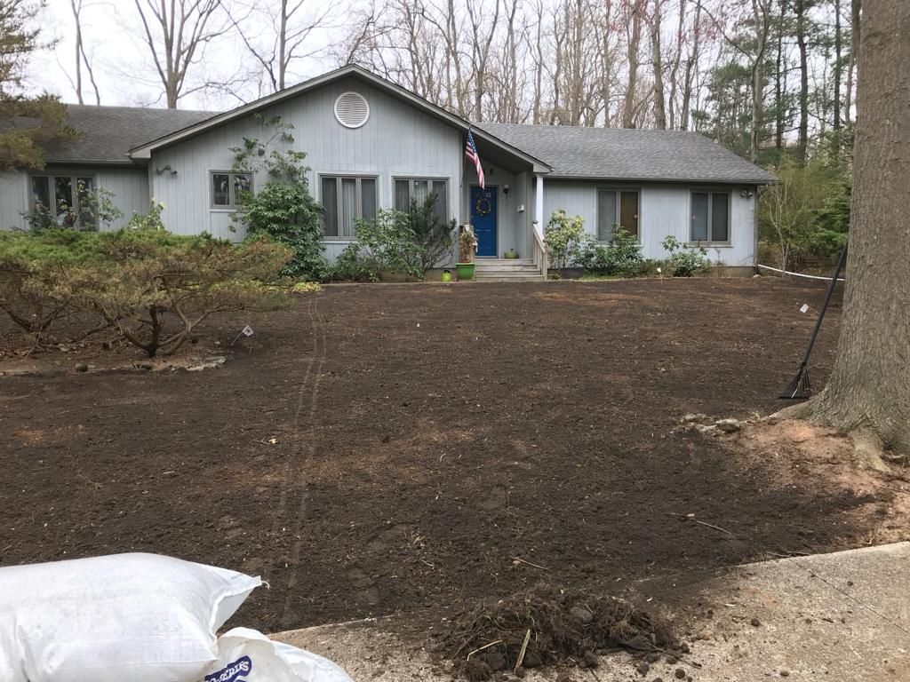 A bag of dirt is sitting in front of a house.