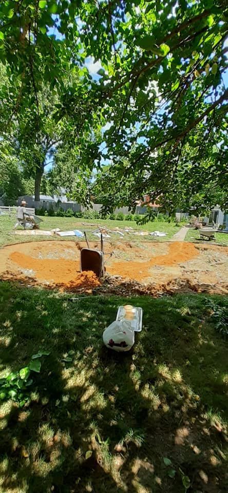 There is a hole in the ground in the middle of a park.