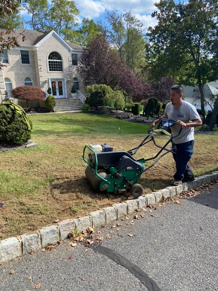 A man is using a lawn mower to mow a lawn in front of a house