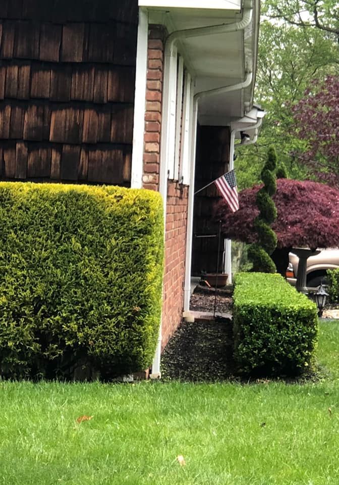 A brick house with a lush green lawn in front of it.