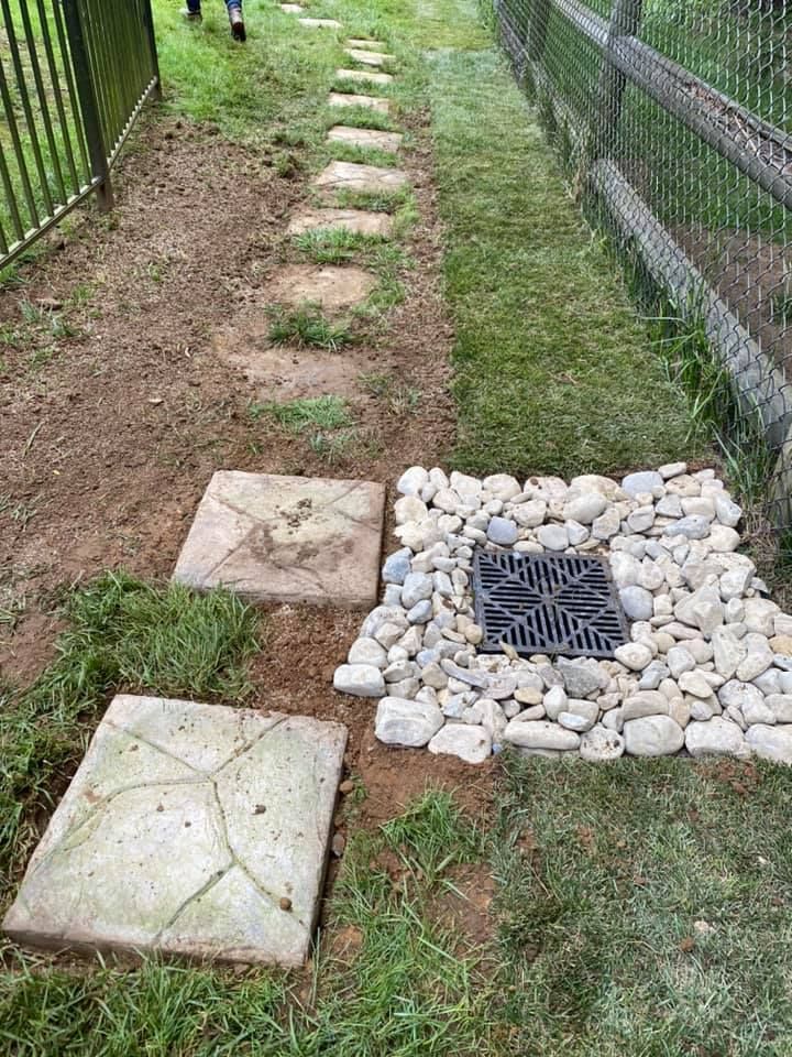 A stone walkway with a drain in the middle of it.