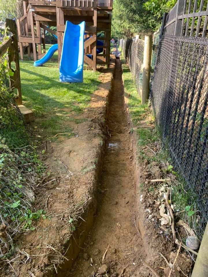A blue slide is being built in a backyard next to a fence.