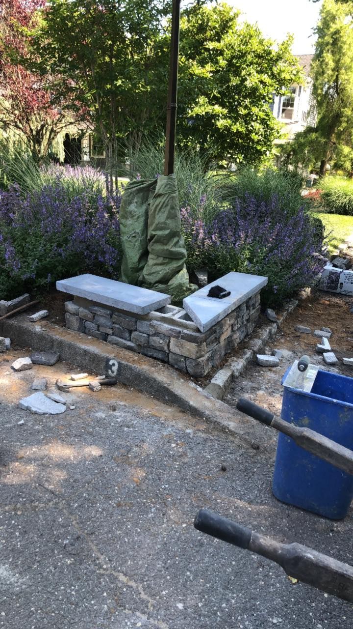 A stone bench is being built in a garden.