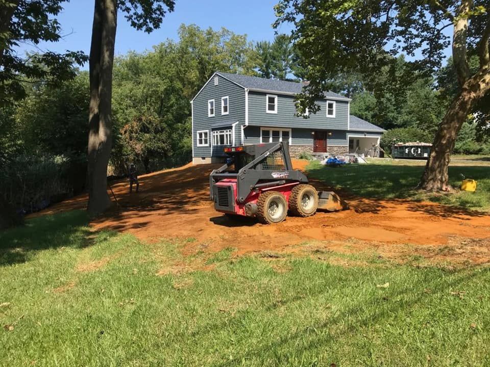 A small red bulldozer is parked in front of a house
