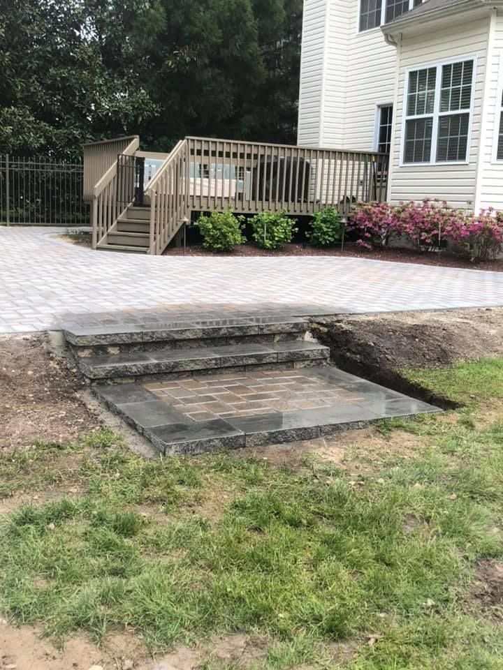 A house with a deck and stairs in front of it.