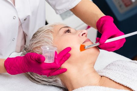A woman is getting a facial treatment at a beauty salon.