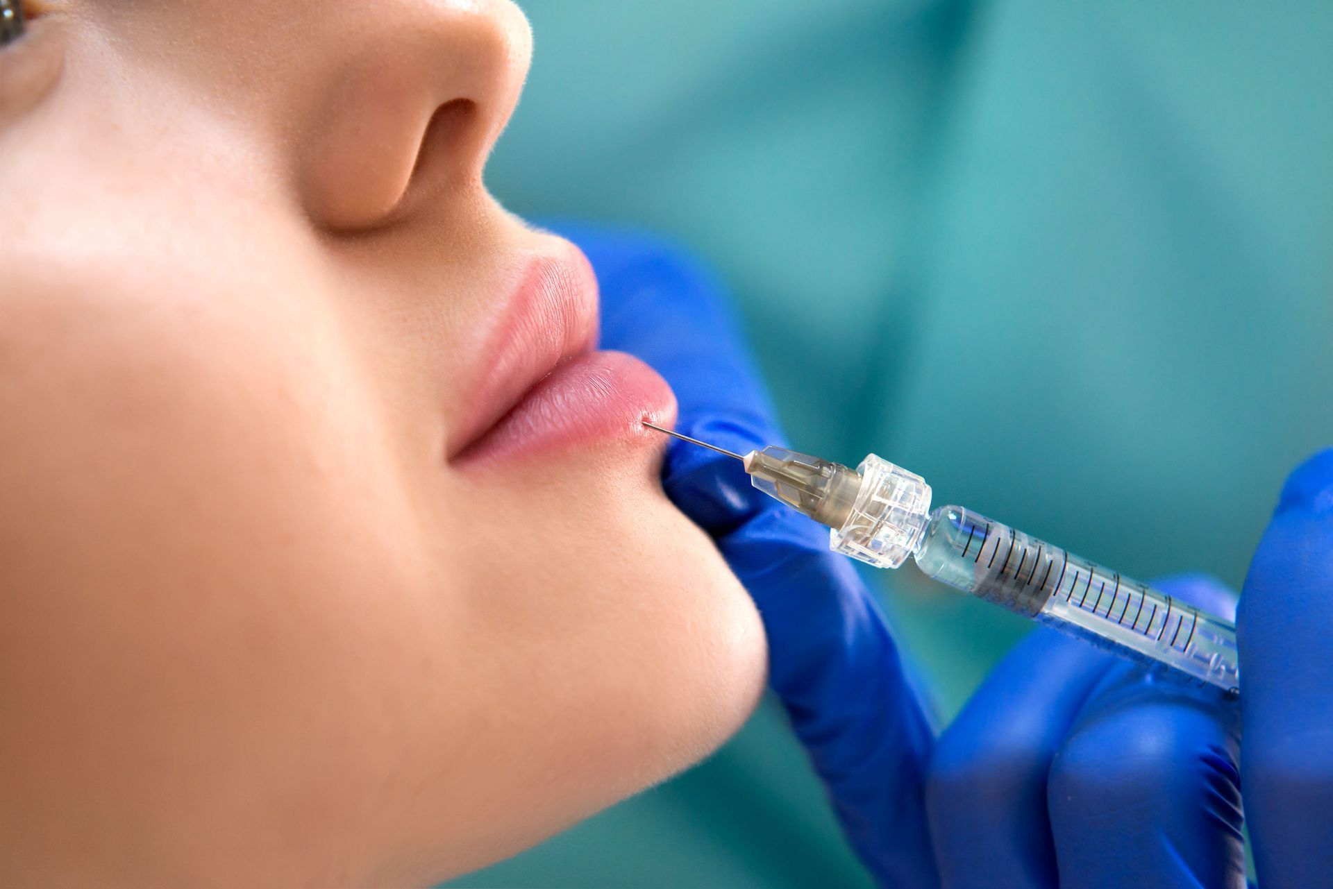 A woman is getting an injection in her lips.