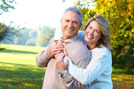 A woman is hugging a man in a park.