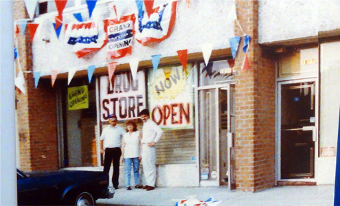 Two people standing in front of a store that is now open