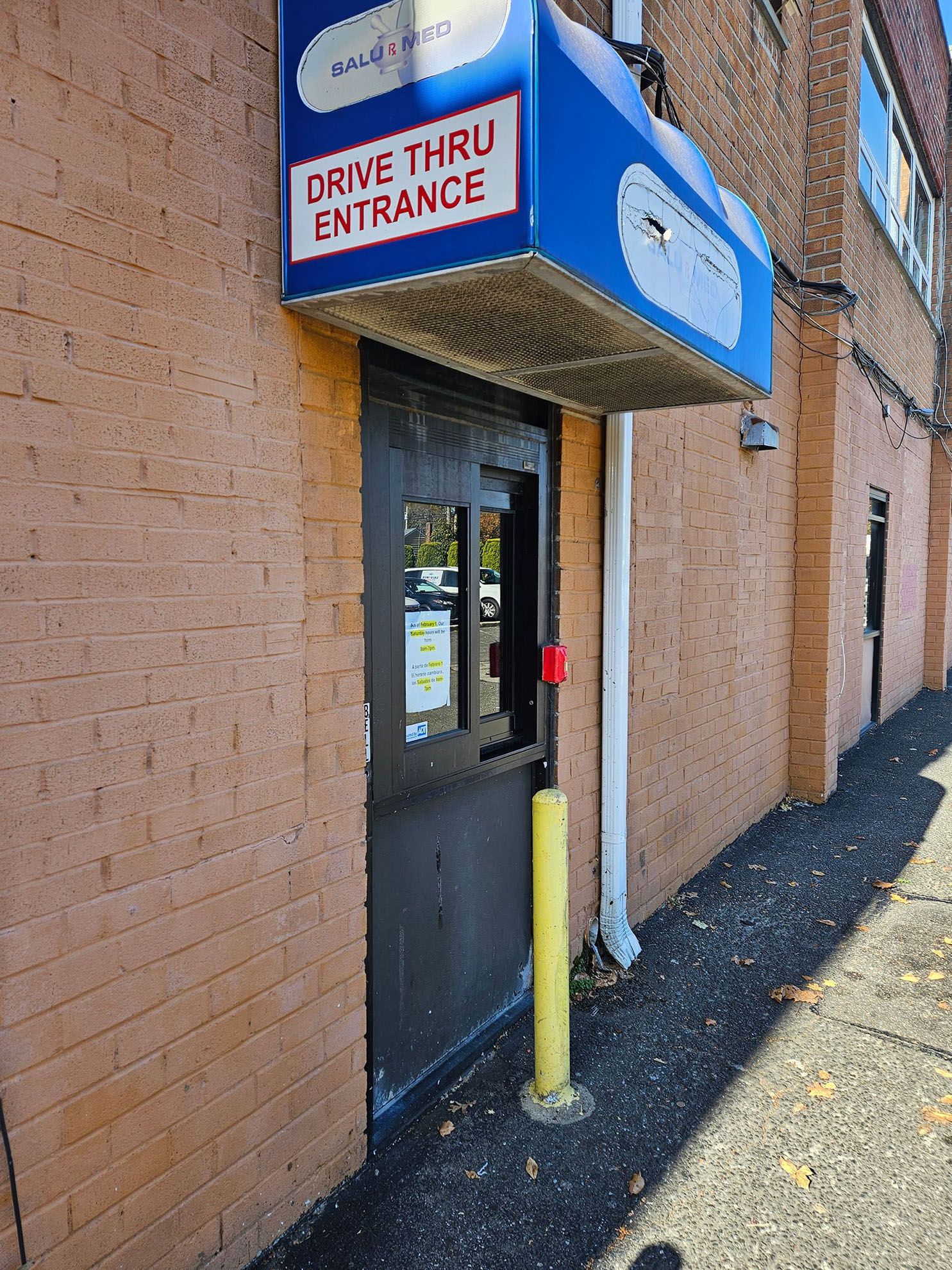 A drive thru entrance sign is above the door of a building.