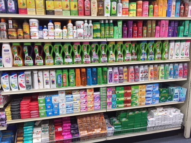 A store shelf filled with lots of different types of shampoo and conditioner.