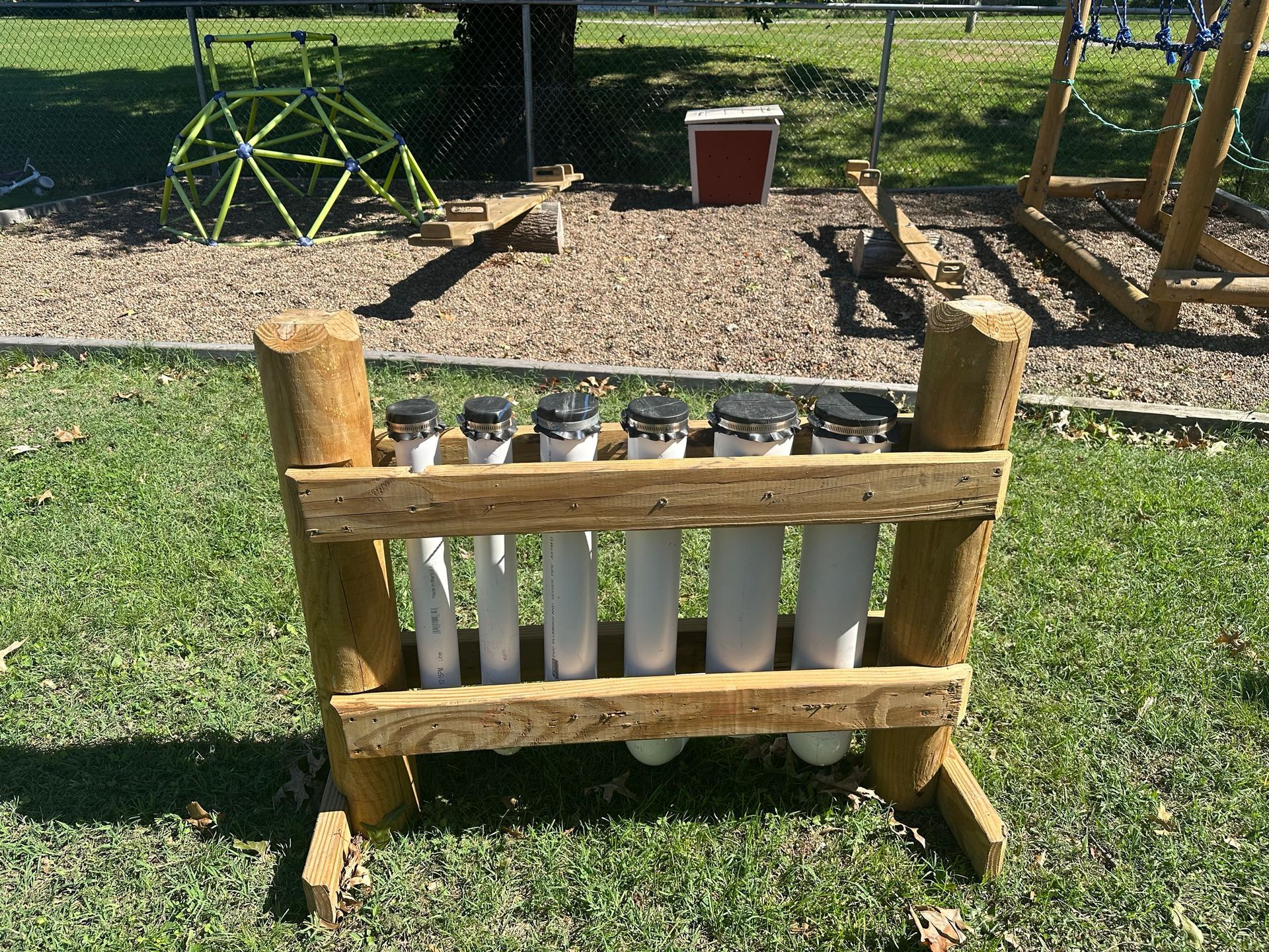 A wooden fence with a bunch of pipes in it