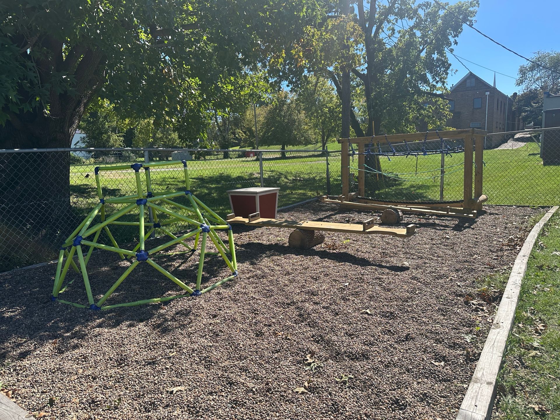 A playground with a monkey bars and a drum.