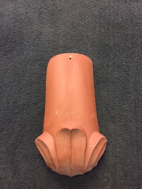 A clay tile with a hole in the middle is sitting on a carpet