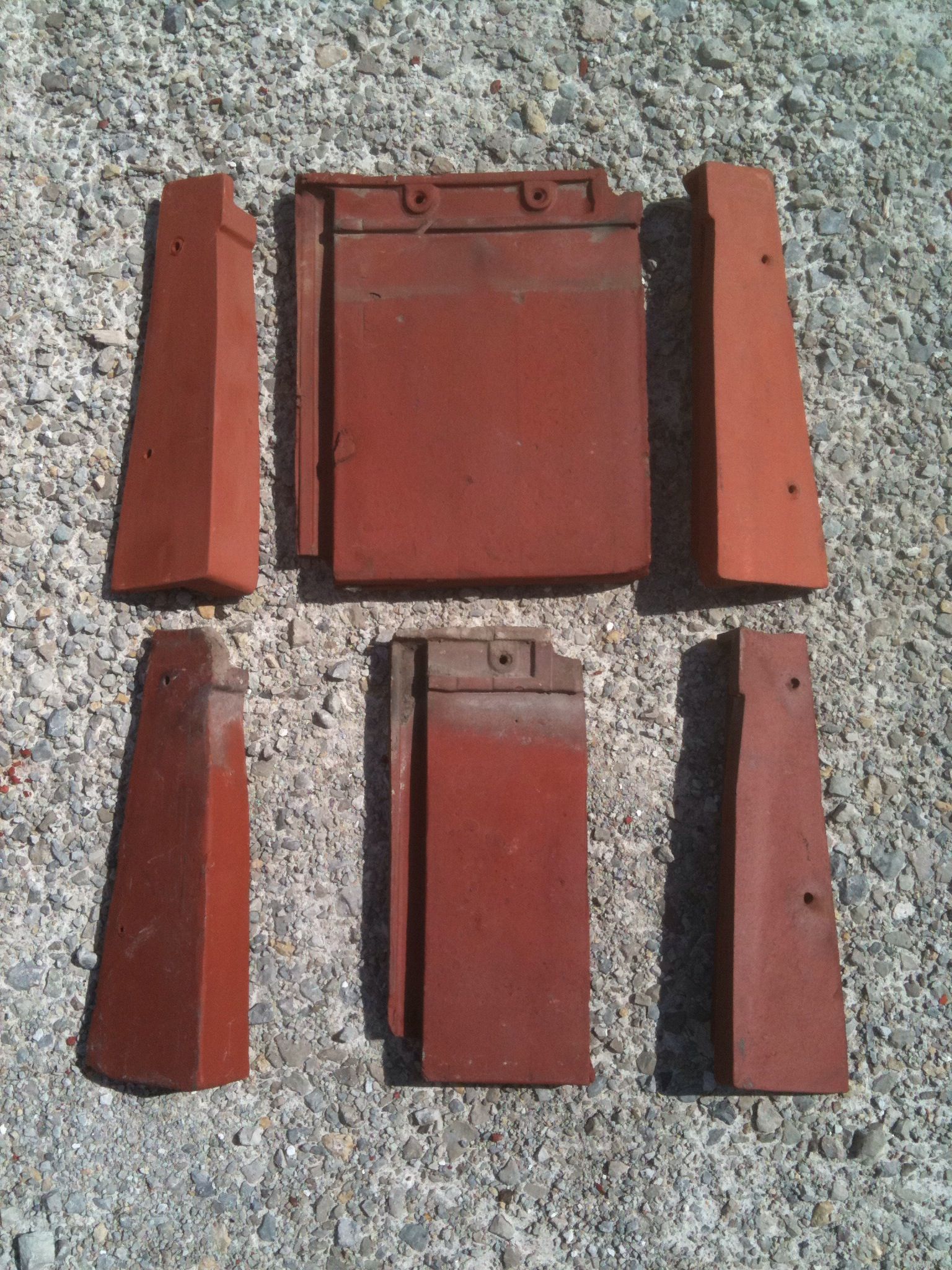 A bunch of red tiles are laying on the ground