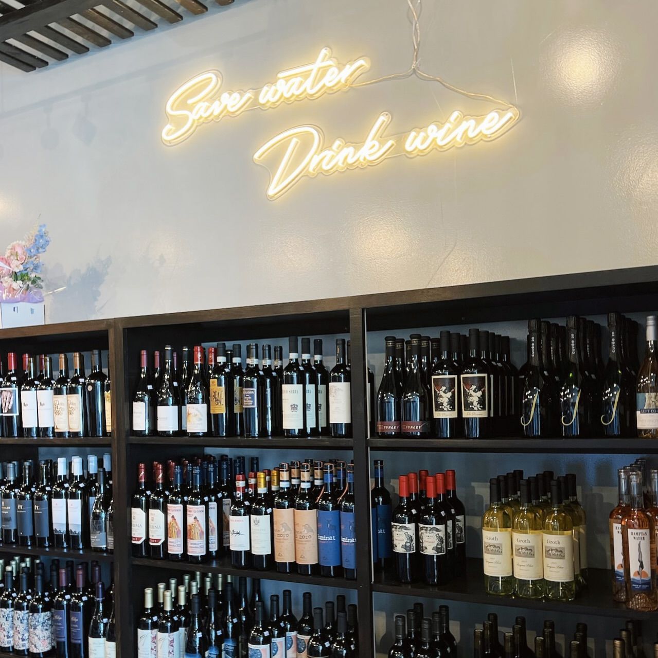 Wine shop interior with shelves of bottles below a