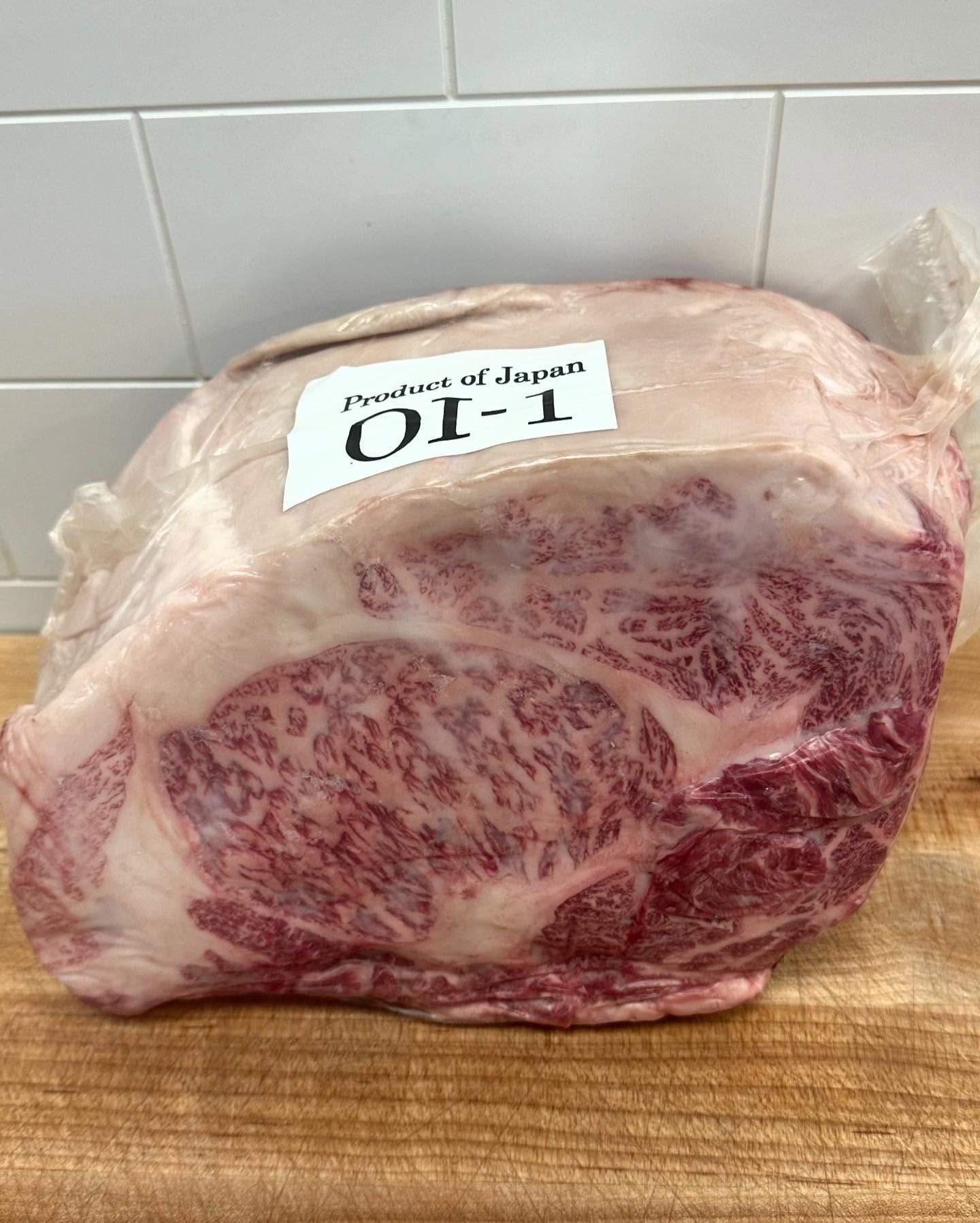 A large, raw cut of Japanese Wagyu beef, with a label reading