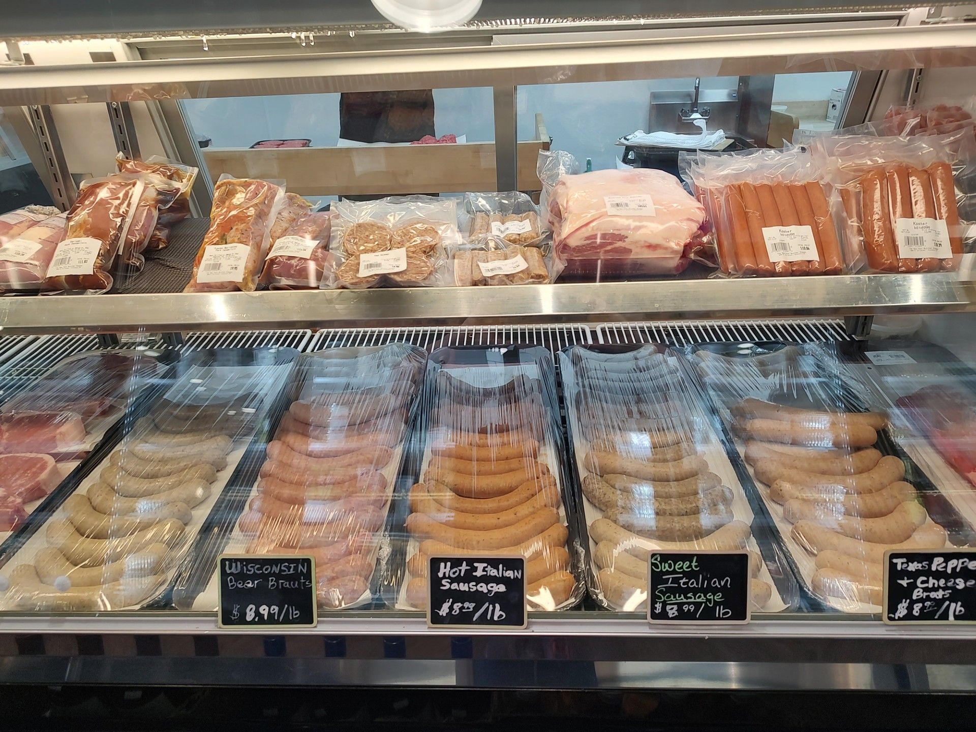 Meat display case with various cuts of packaged meats.
