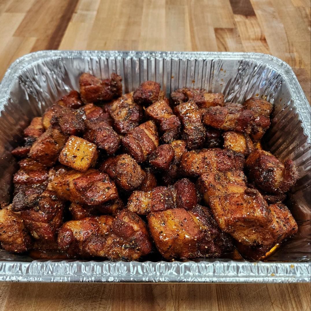 Tray of smoked pork belly burnt ends, browned with seasoning.