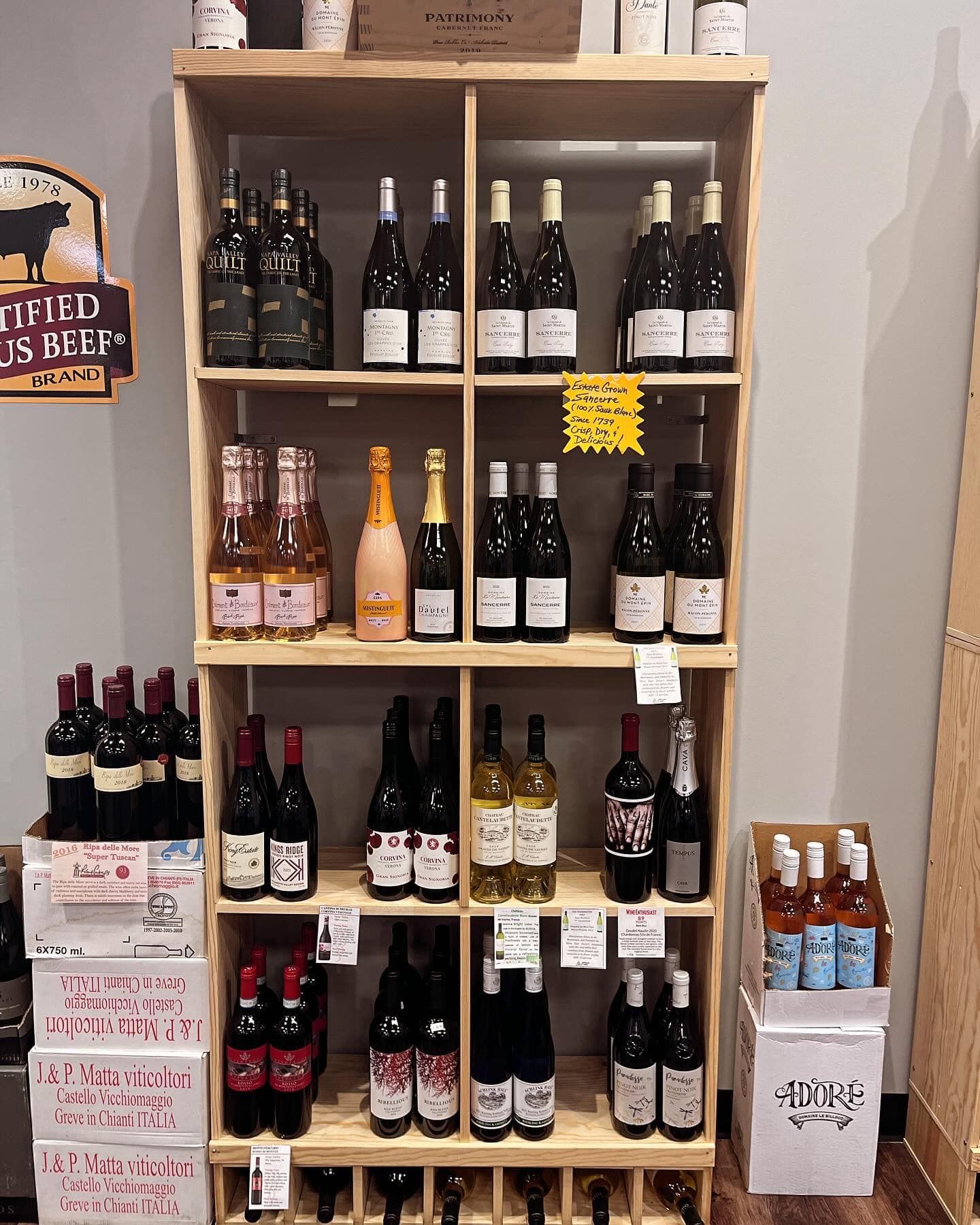 Wooden shelf filled with various wine bottles in a store.