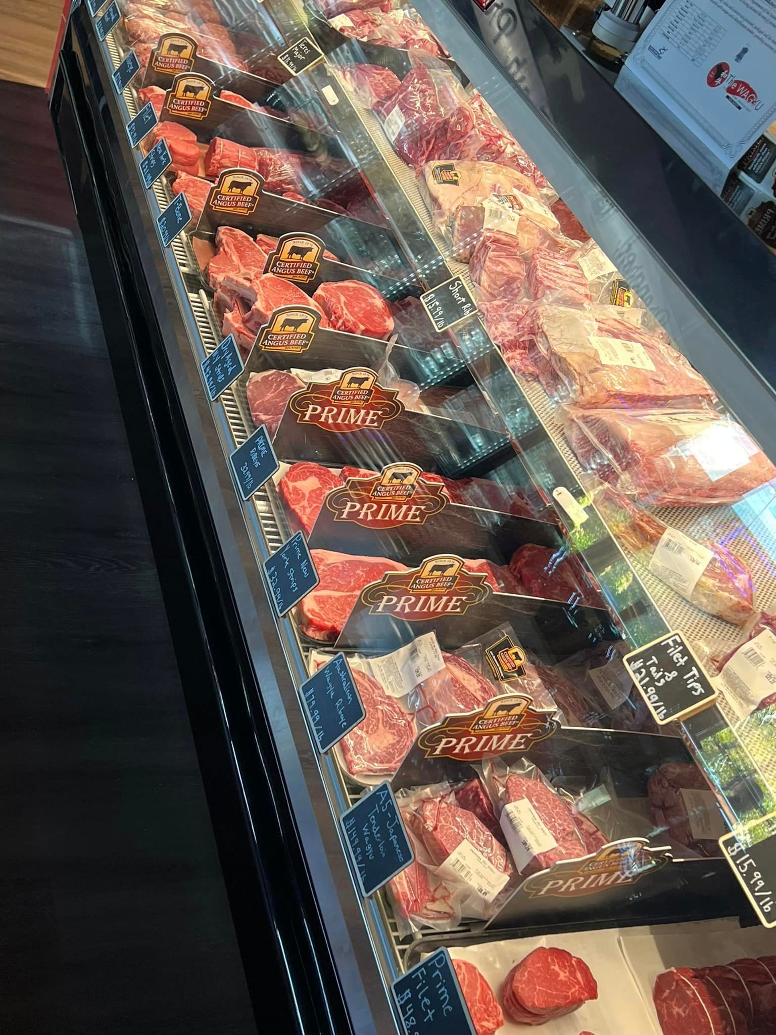 Meat display case with various cuts of raw beef.