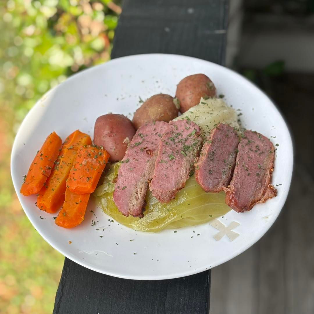 Corned beef and cabbage plate with carrots and potatoes.