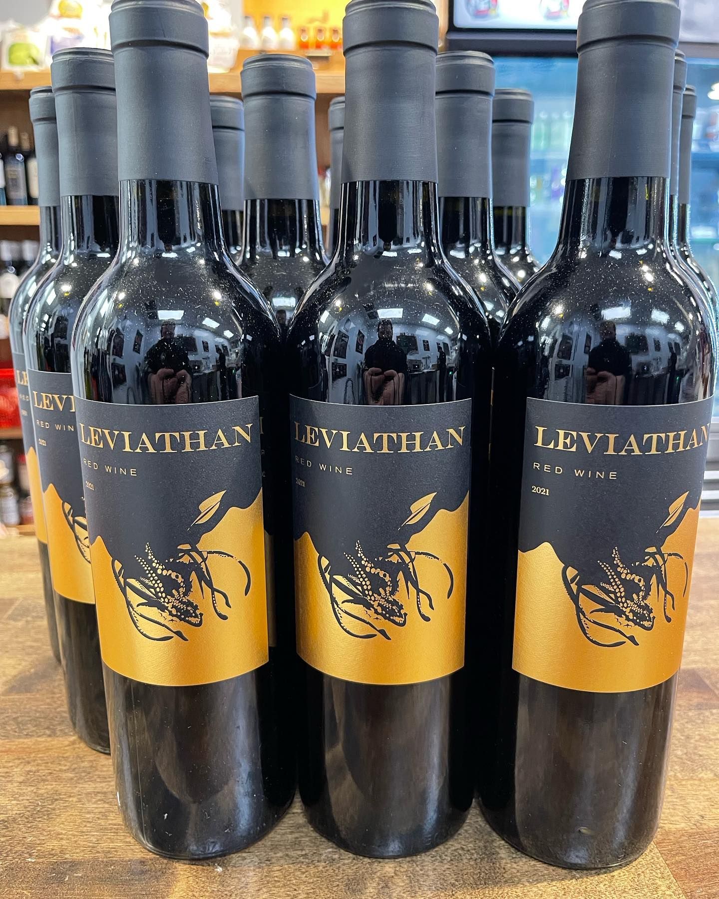 Bottles of Leviathan Red Wine, black bottles with black and gold labels, arranged on a wooden surface.