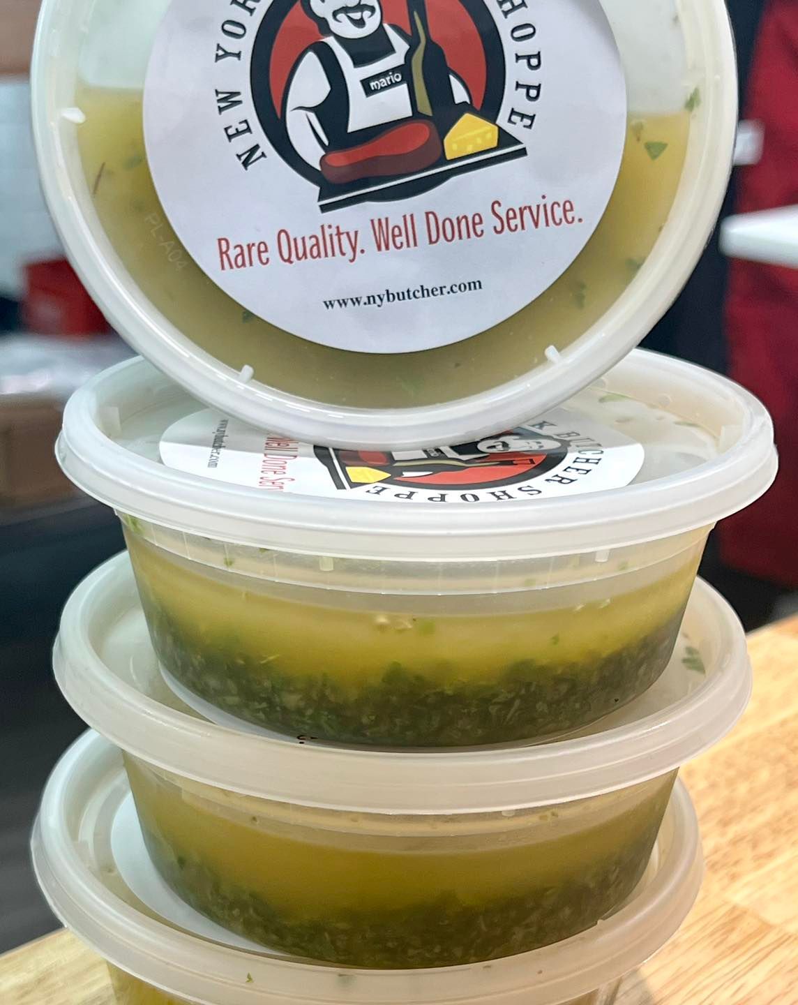 Stack of three containers of green and yellow soup with a label from