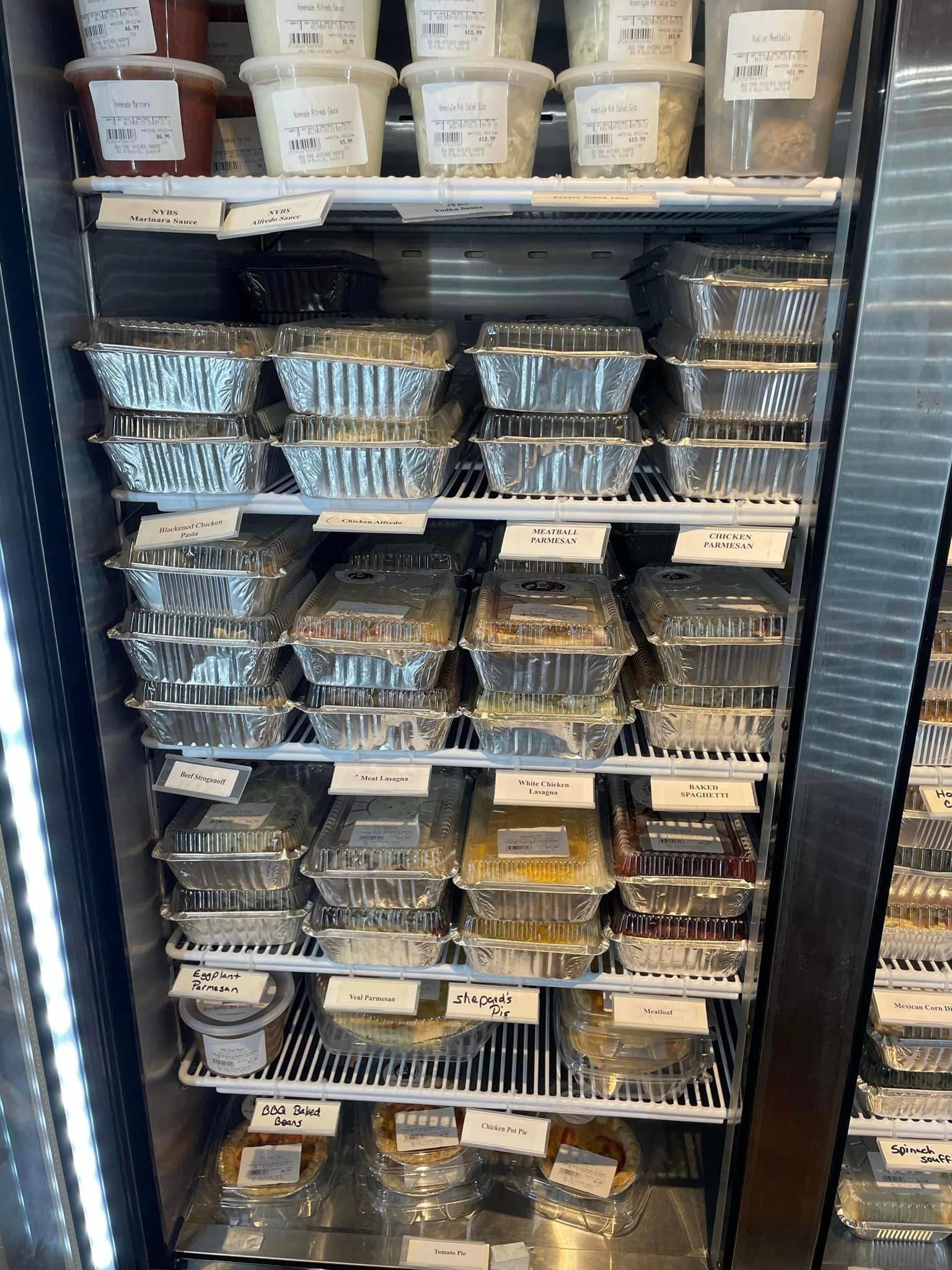 Refrigerator stocked with prepared food containers.