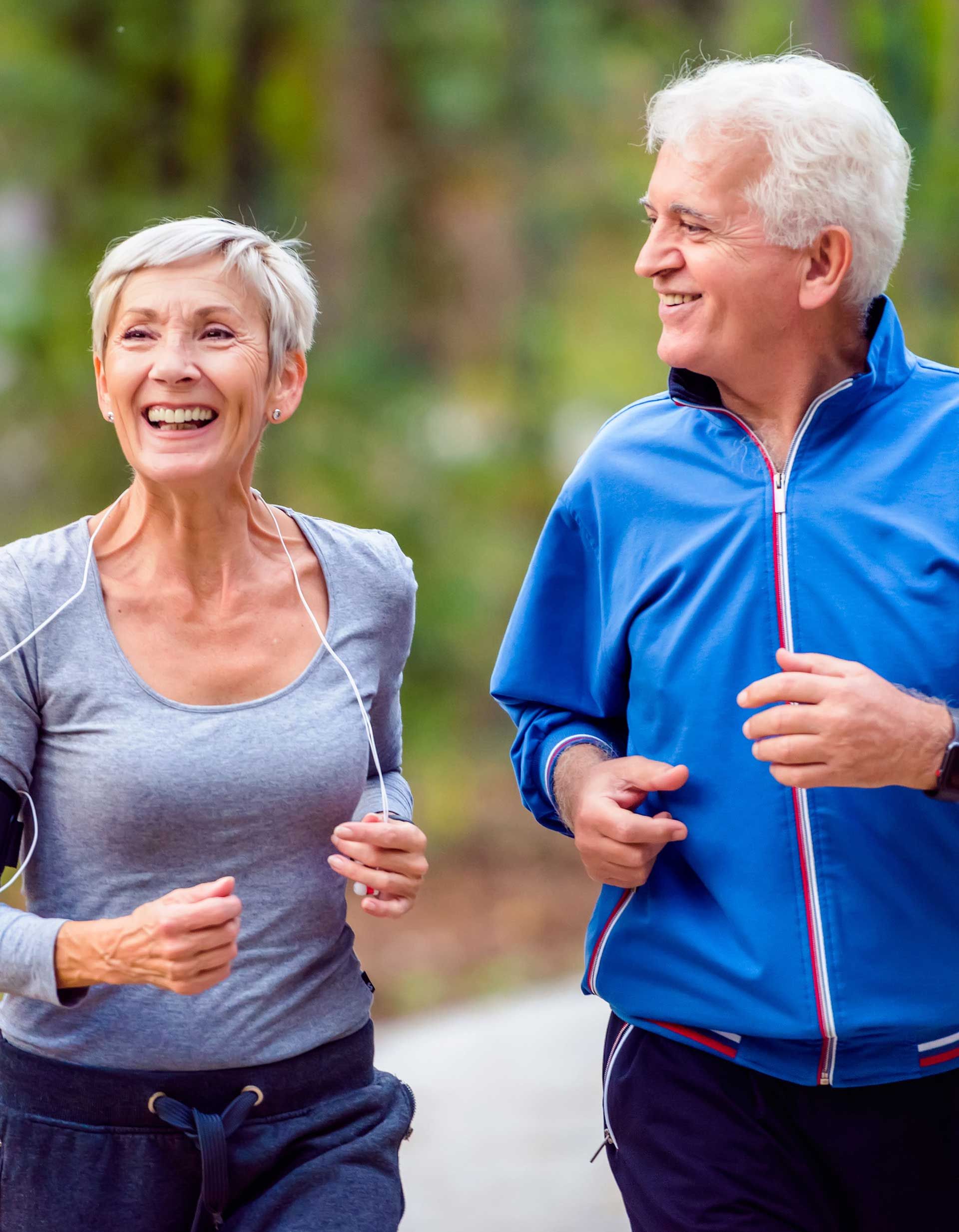 A man and a woman are jogging together in a park.