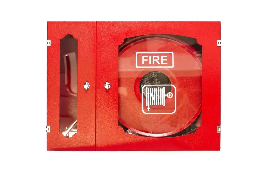 A red fire alarm box with a glass door on a white background.