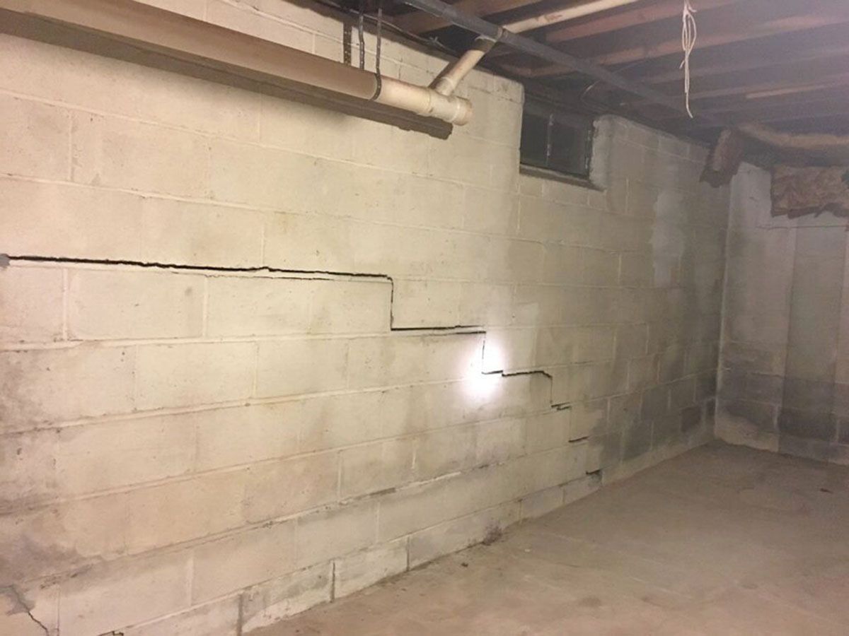 Basement with cinder block walls, exposed beams, and a concrete floor
