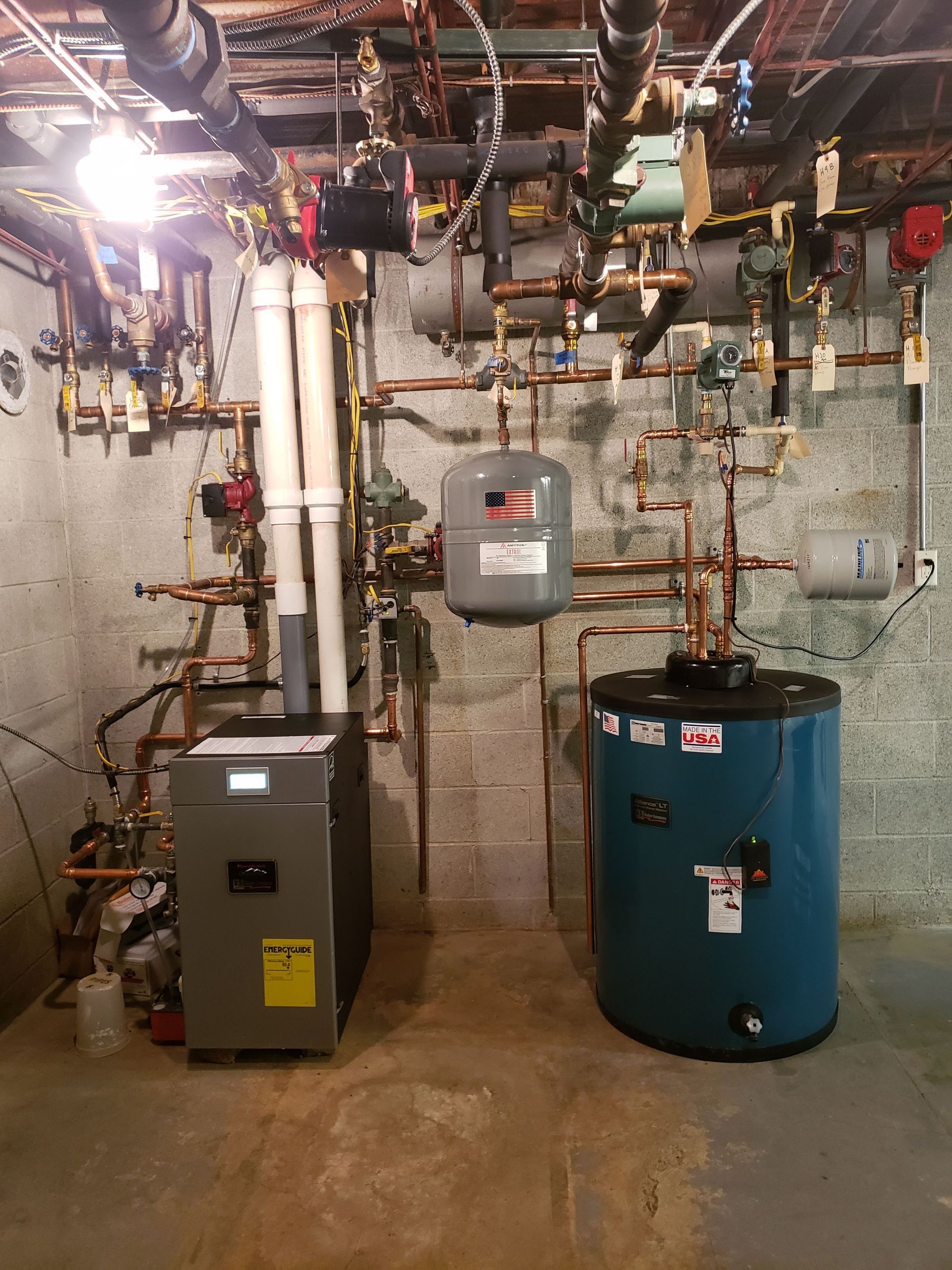 A room with a boiler and a water heater in it.