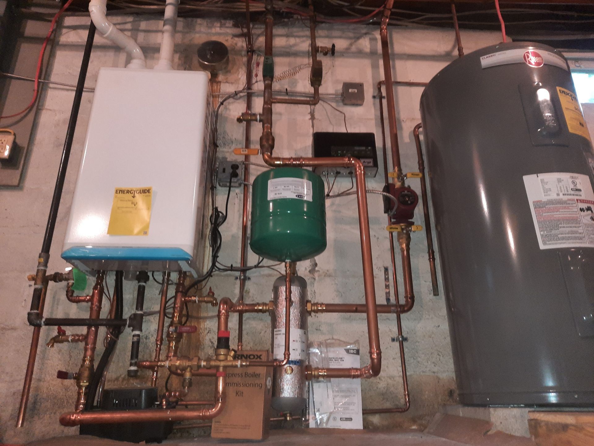 A water heater and a water tank are connected to a wall.