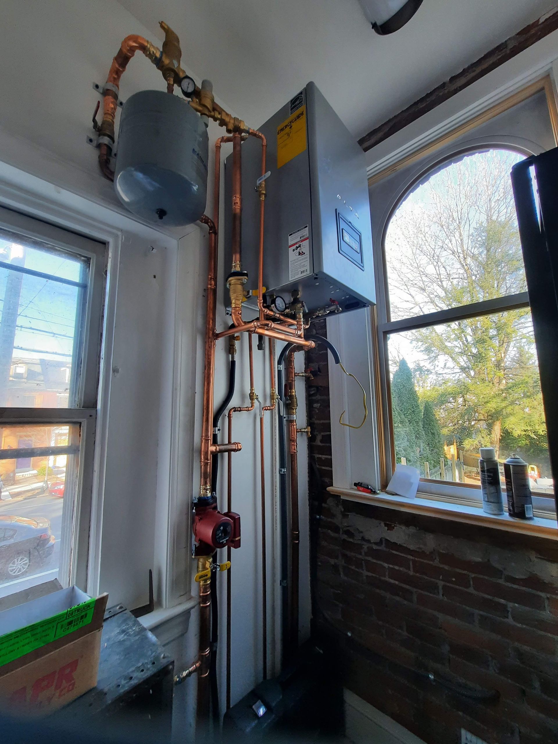 A room with a lot of pipes and a window.