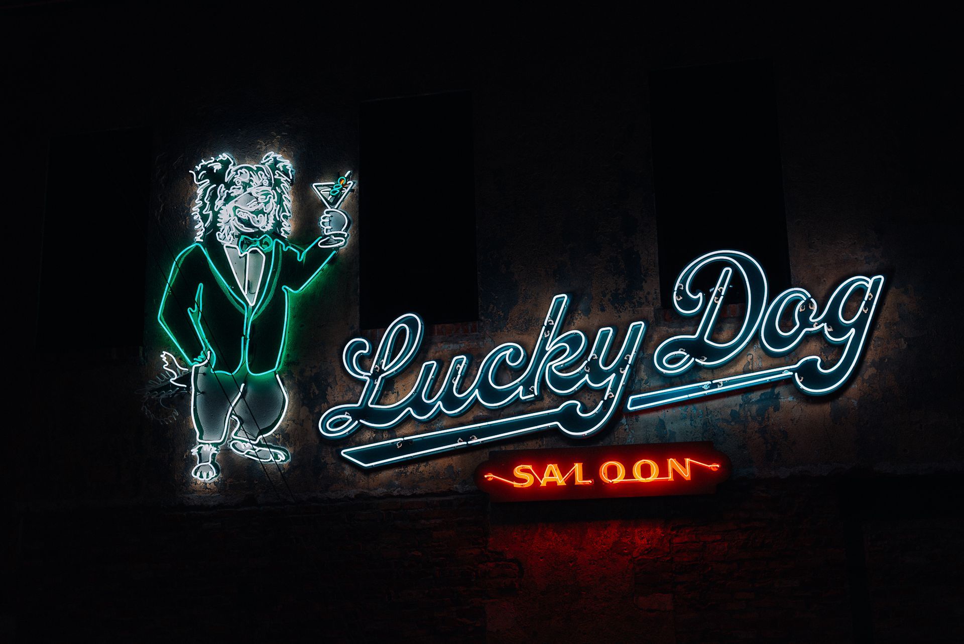 Neon sign of a dog in a tuxedo, holding a cocktail. 