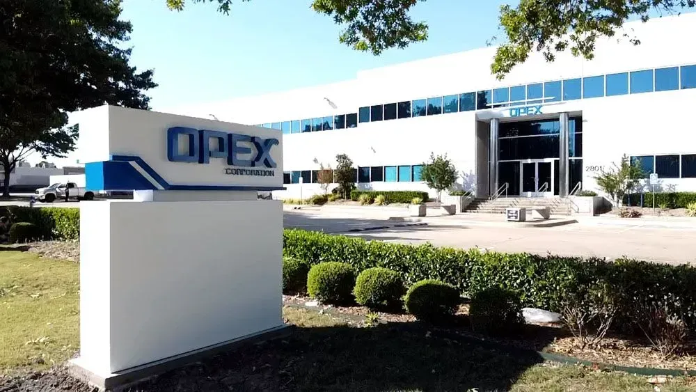 Sign for DIPEX Corporation in front of a modern, white building with blue-tinted windows.