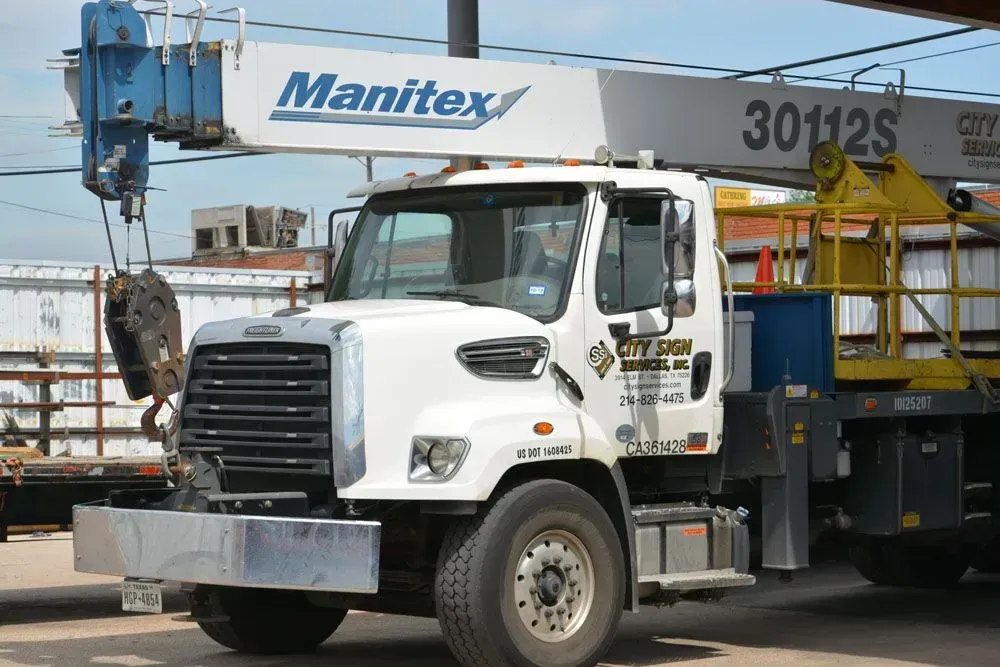White Manitex crane truck with boom extended.