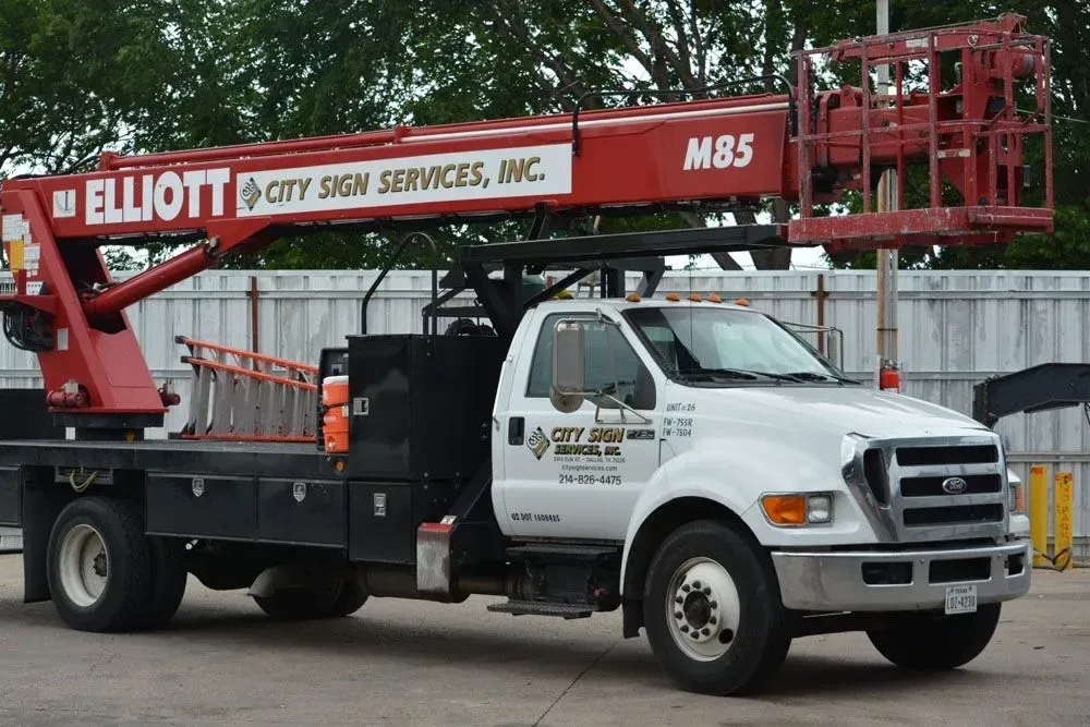 Red and white Elliott M85 boom truck for City Sign Services.