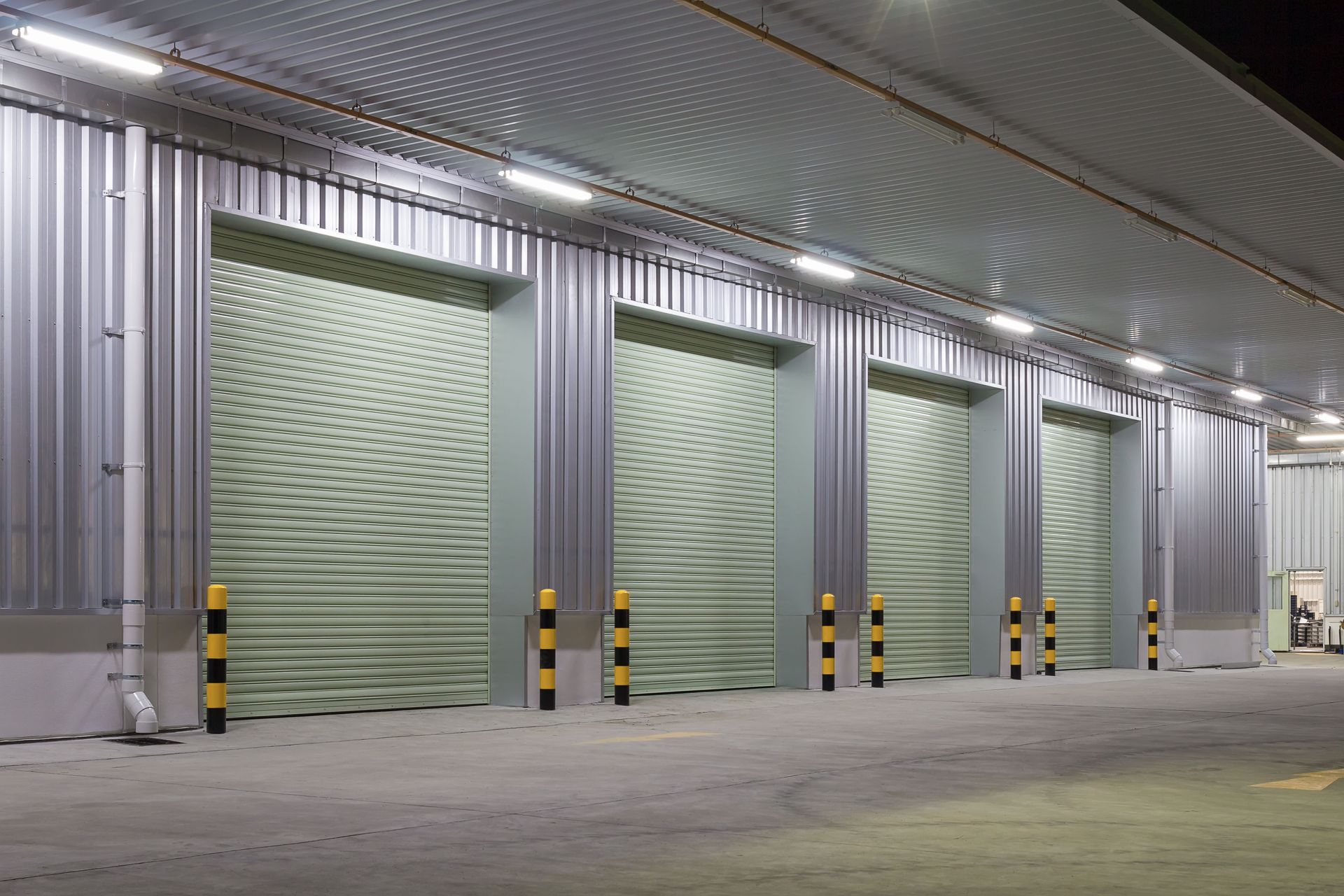A row of garage doors in a warehouse at night