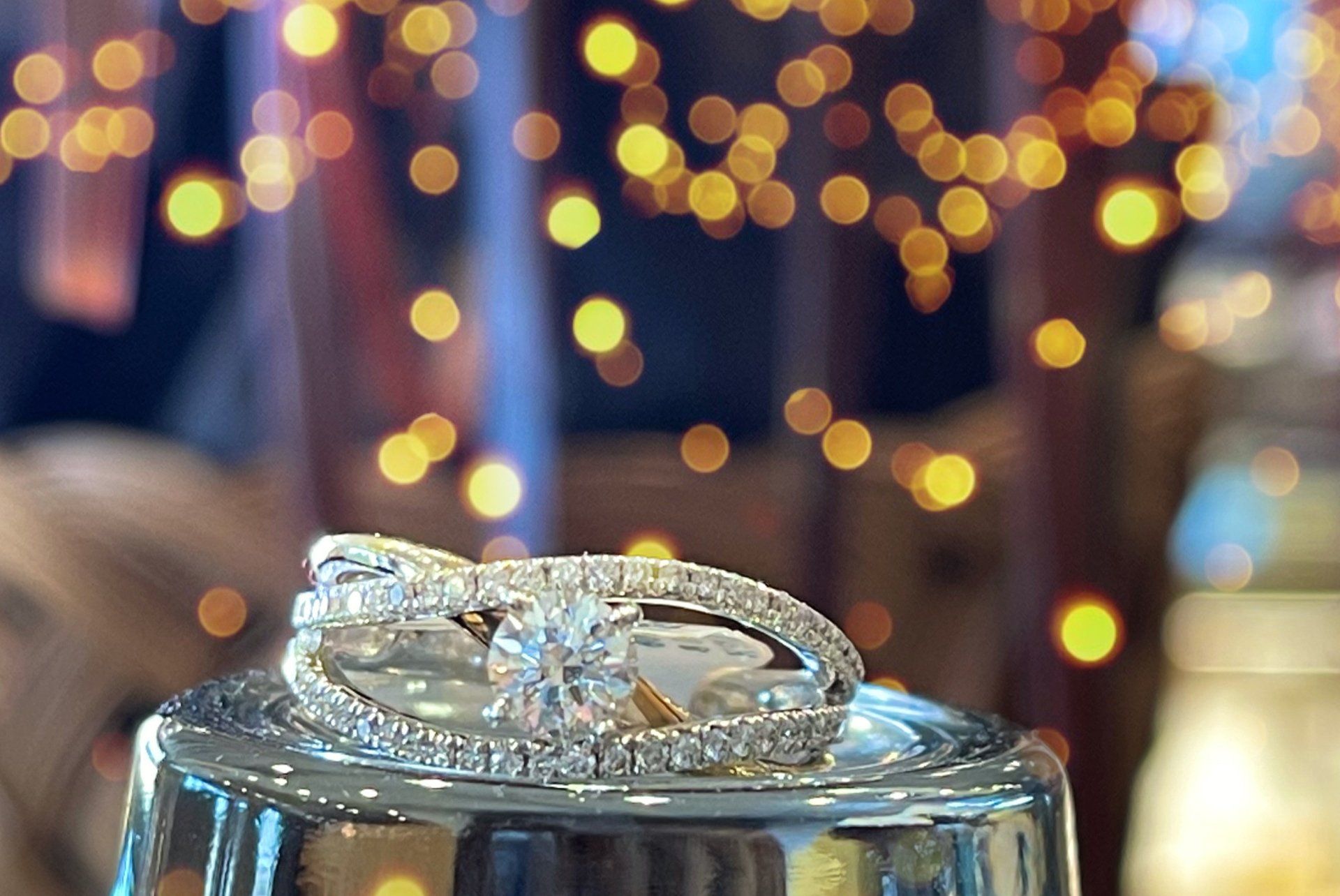 A couple of wedding rings sitting on top of a glass.