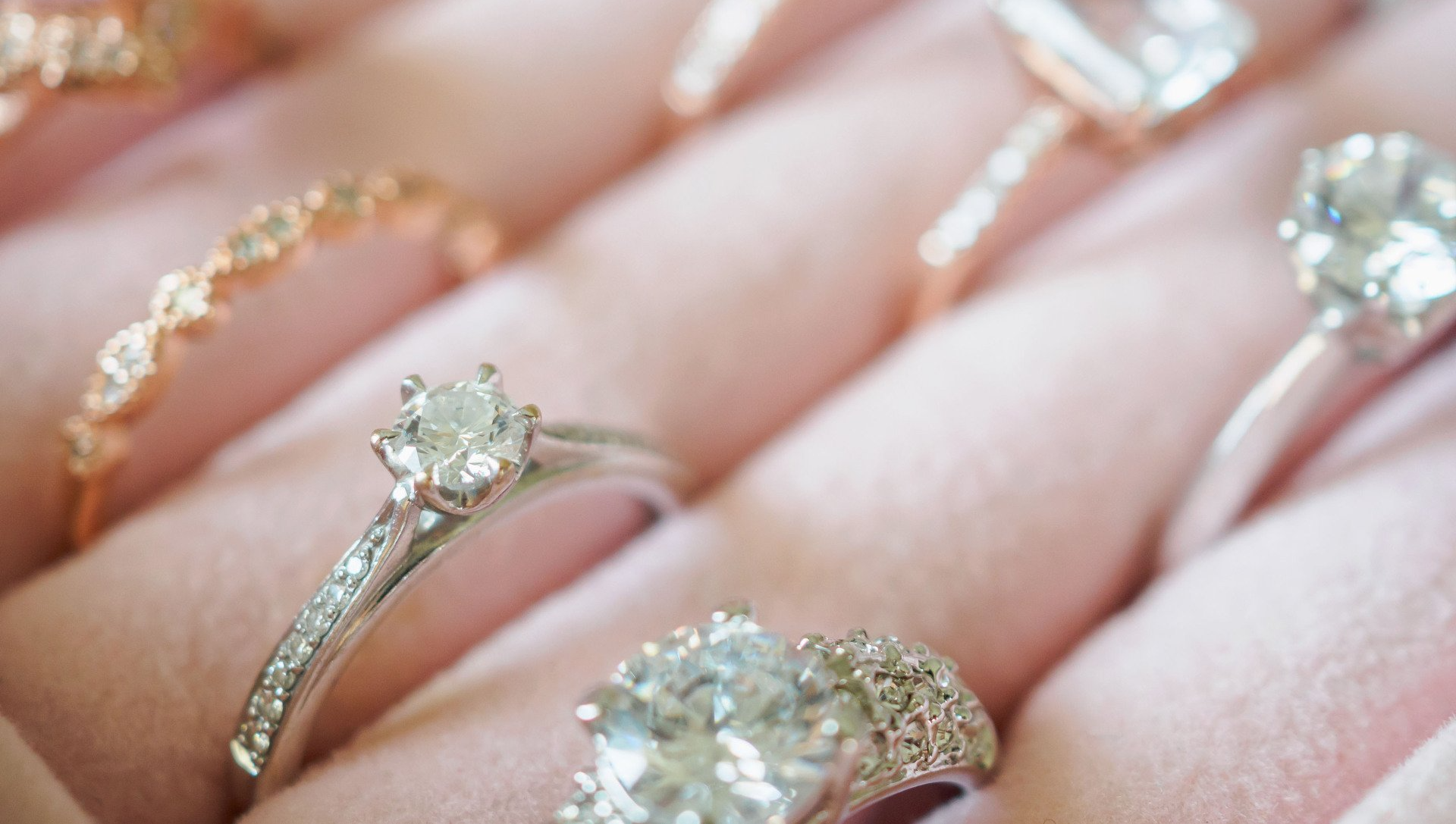 A person is holding a bunch of rings on their fingers.