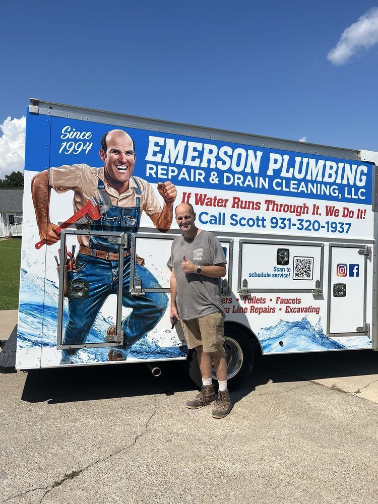 Plumber posing beside Emerson Plumbing service truck with water damage repair advertisement