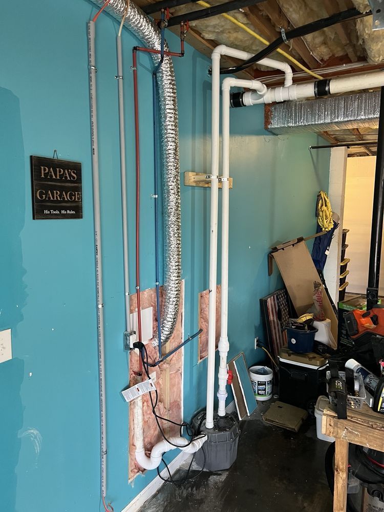 Turquoise utility room with exposed pipes, water heater, and cluttered storage area.