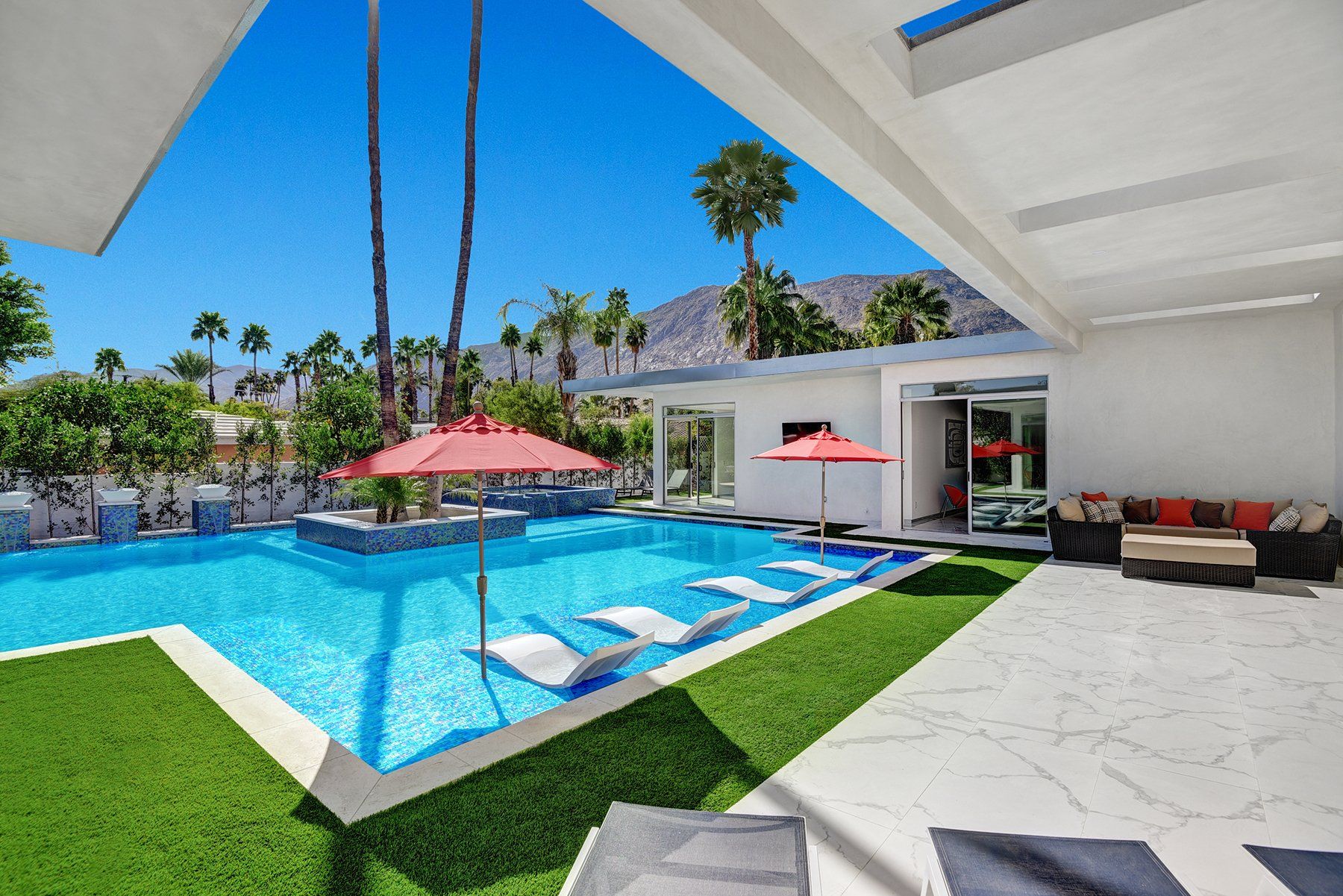 Covered patio to pool and sunken fire pit at night