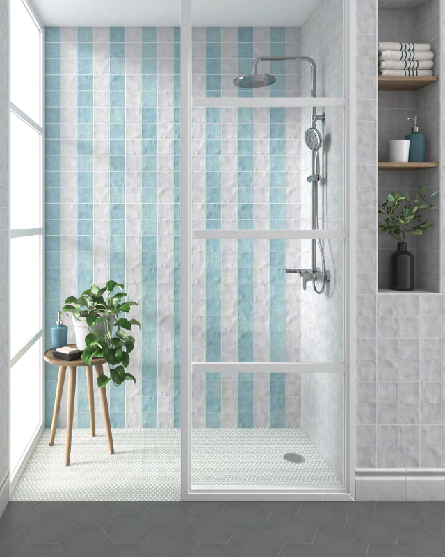 Blue and white striped tiled shower with glass enclosure, round showerhead, and small side table.