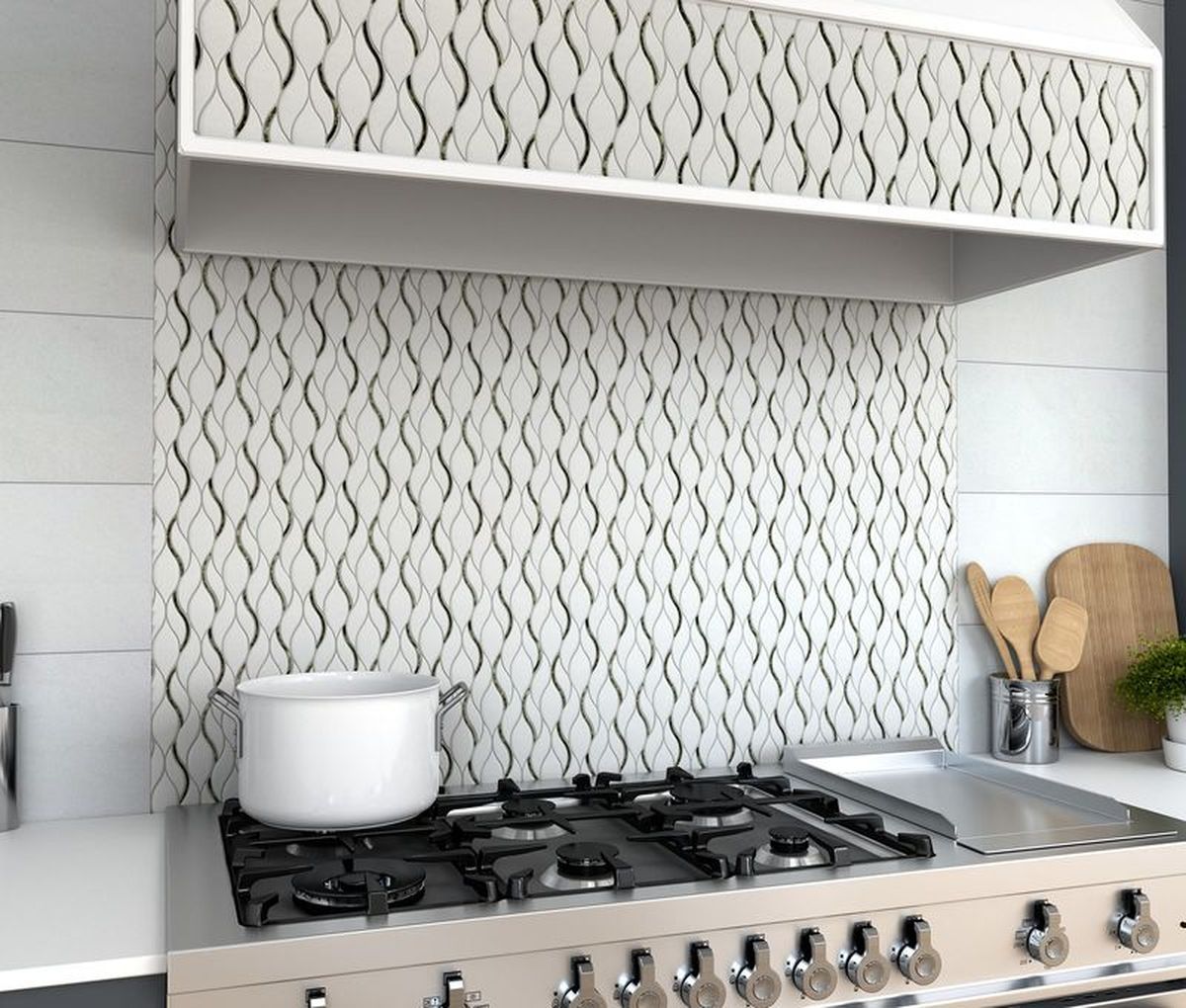 Kitchen stove with white pot, tiled backsplash, and hood with repeating wave pattern.